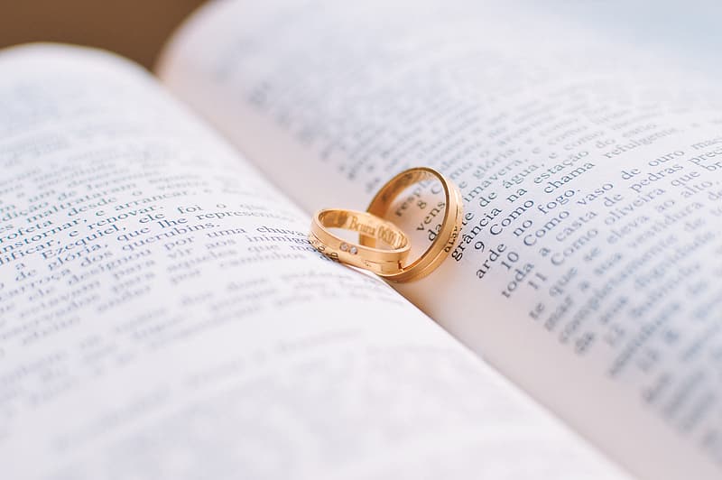 two-gold-colored-rings-on-book